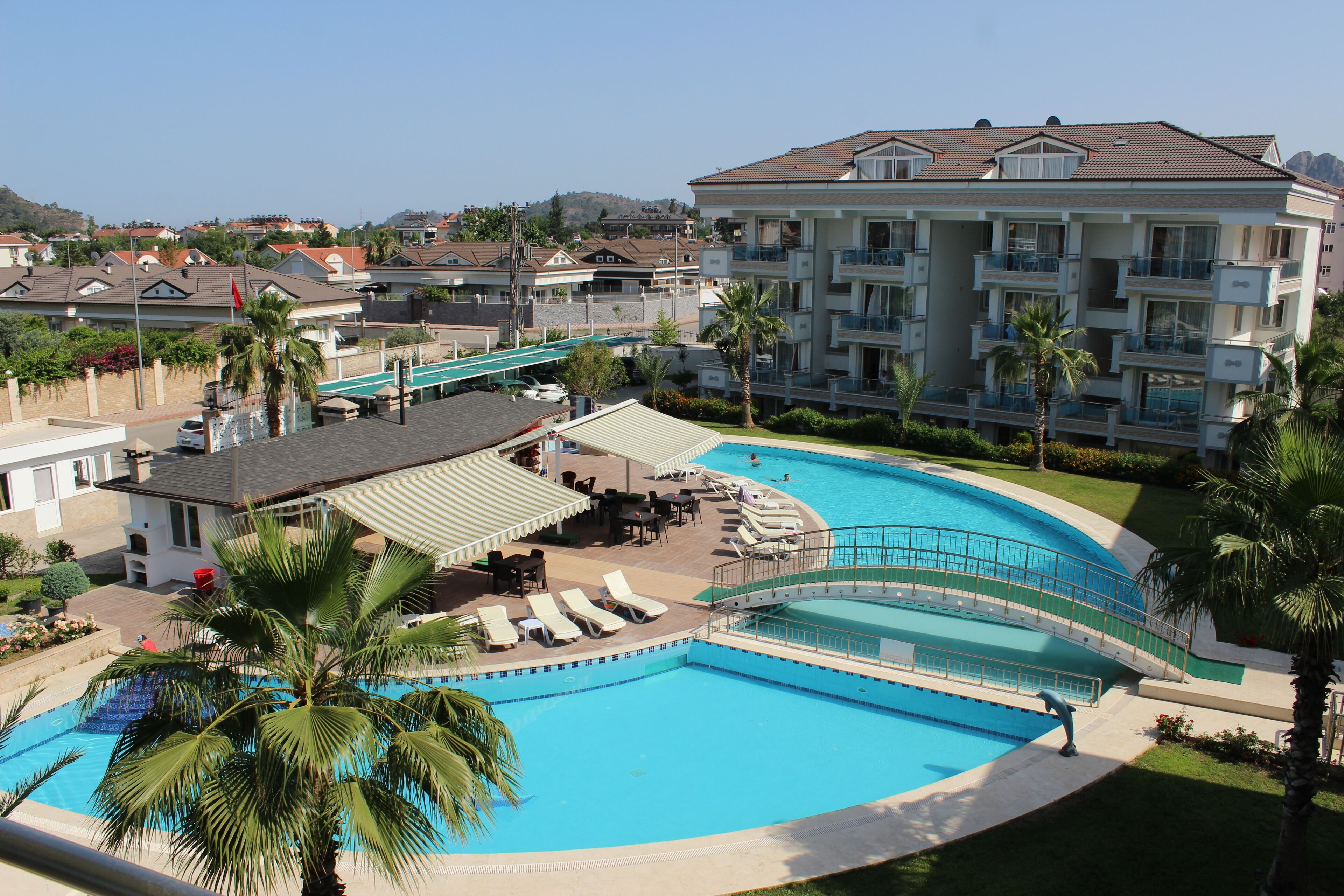 حمّام سباحة خارجي، مظلات على حمّام السباحة، مقاعد للتشمس