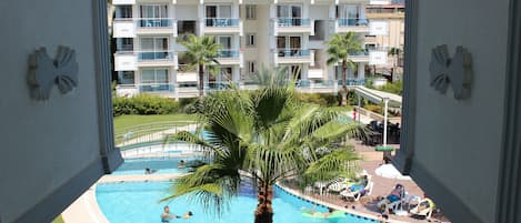 Una piscina al aire libre, sombrillas, tumbonas