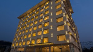 Un hôtel à plusieurs étages au design moderne, doté d’un toit plat et de nombreuses fenêtres.