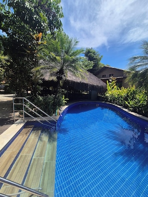 Una piscina al aire libre, tumbonas