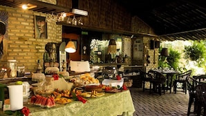 Una mesa de buffet con diferentes platillos y una pared de ladrillo rústica al fondo.