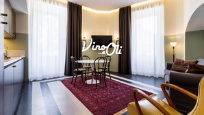 Een moderne woonkamer met een eethoek, met een flatscreen televisie, een bank en een rood tapijtend.