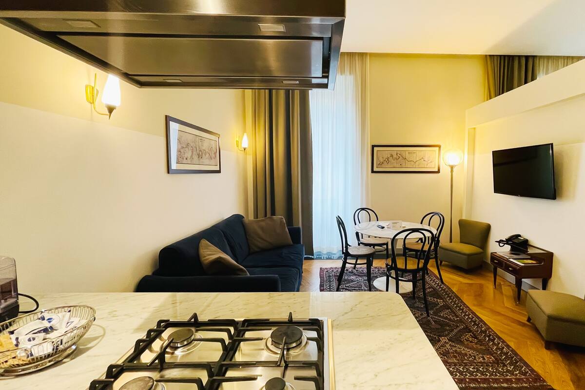 Un espacio habitable compacto con zona de cocina, una mesa de comedor y un sofá.