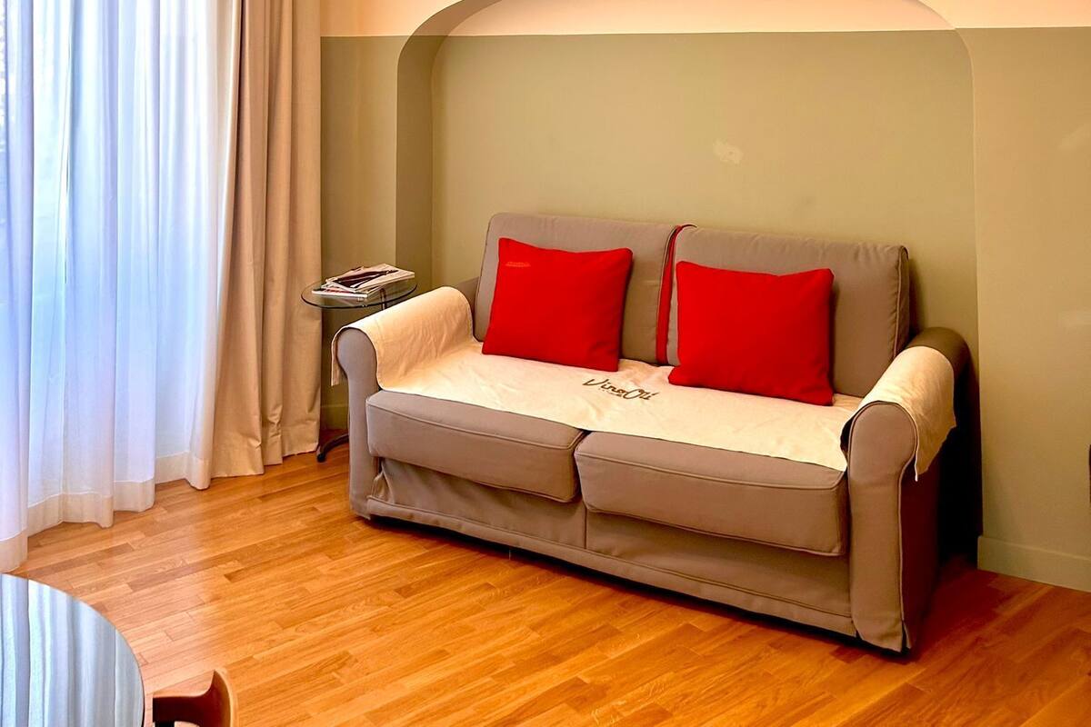 Una sala de estar acogedora con un sofá, una mesita auxiliar y una lámpara en el techo.