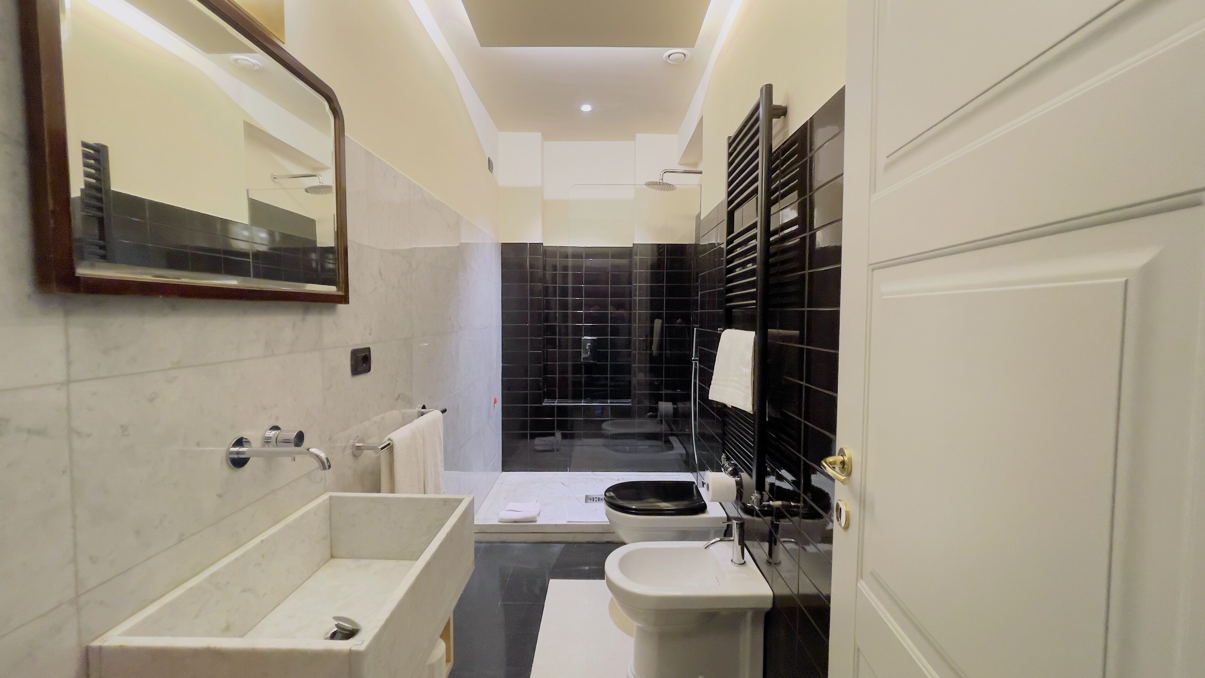 A modern bathroom with a large bathtub, a toilet, and a shower area.