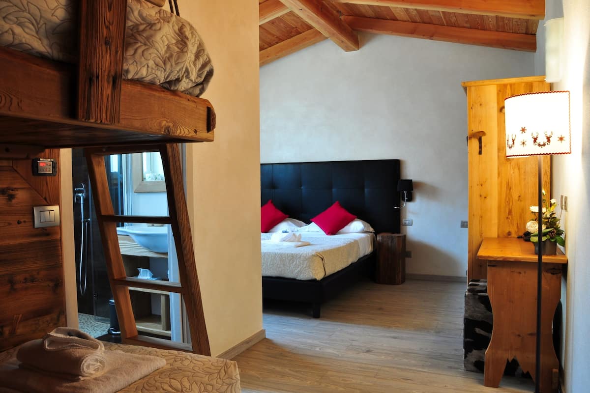 Une chambre à coucher avec un lit, une tête de lit en bois et une table de chevet avec une lampe.