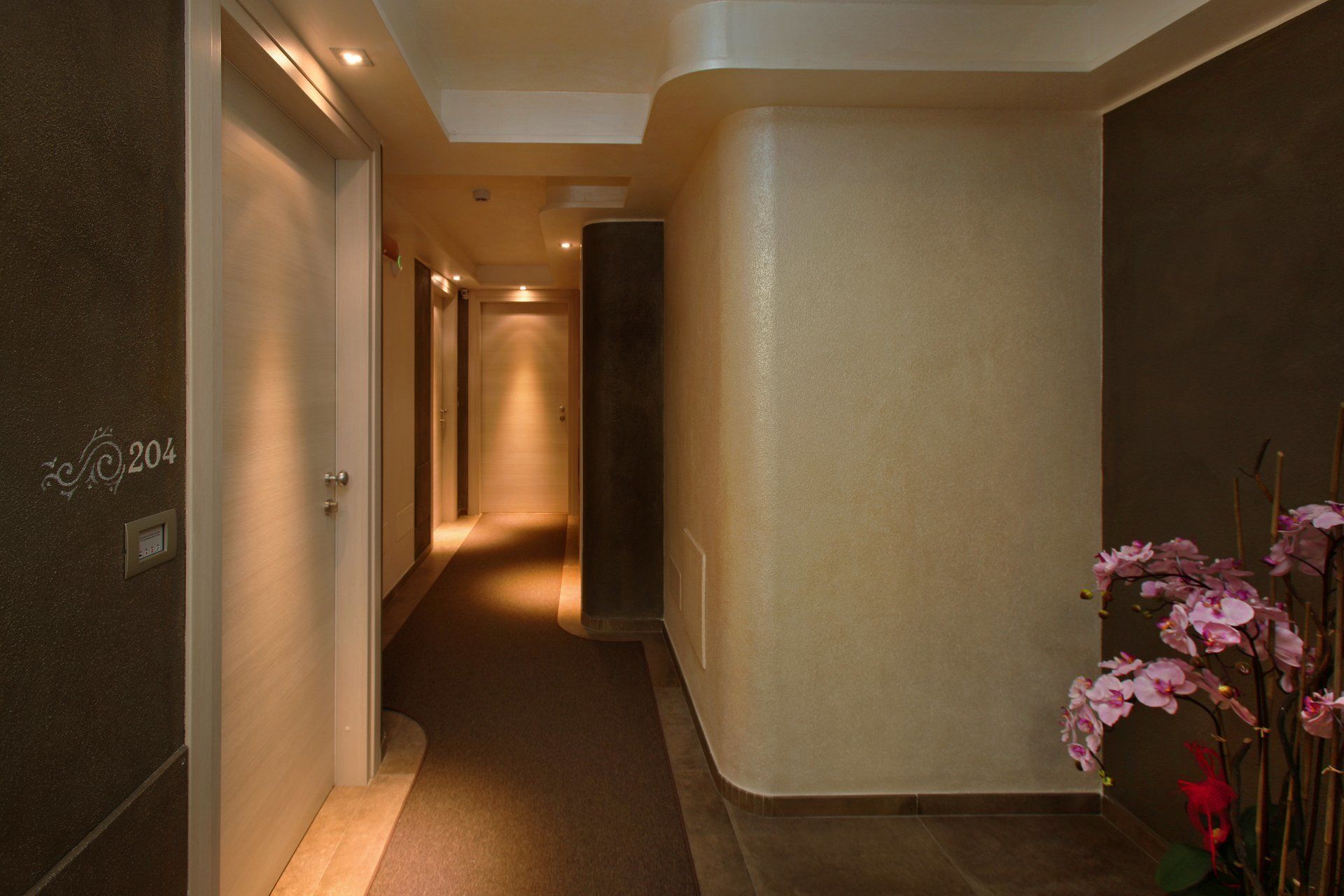 A hallway with a number 204 sign, a plant, and a door at the end.