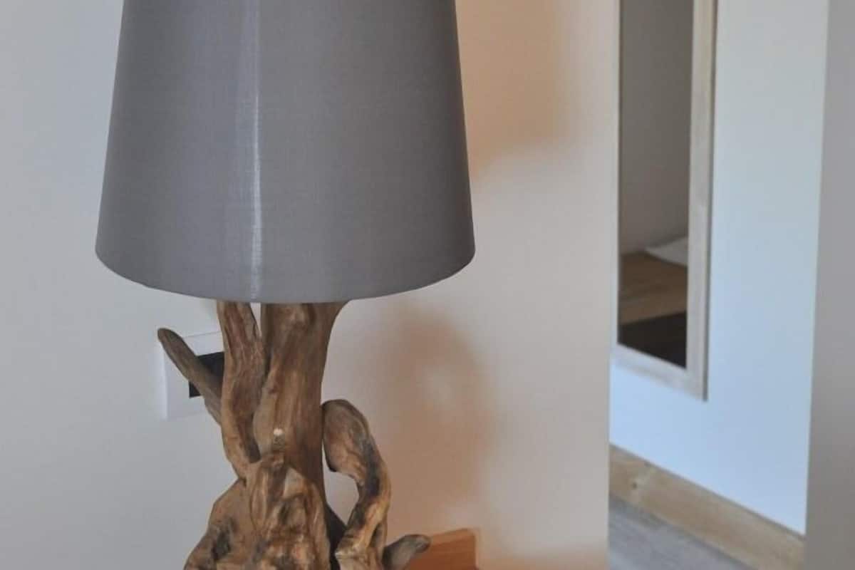 A lamp with a grey shade and a wooden base.