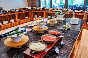 Un bufé con diferentes alimentos y utensilios.