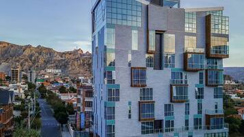 A modern multi-story hotel with a unique architectural design, featuring large windows and balconies.