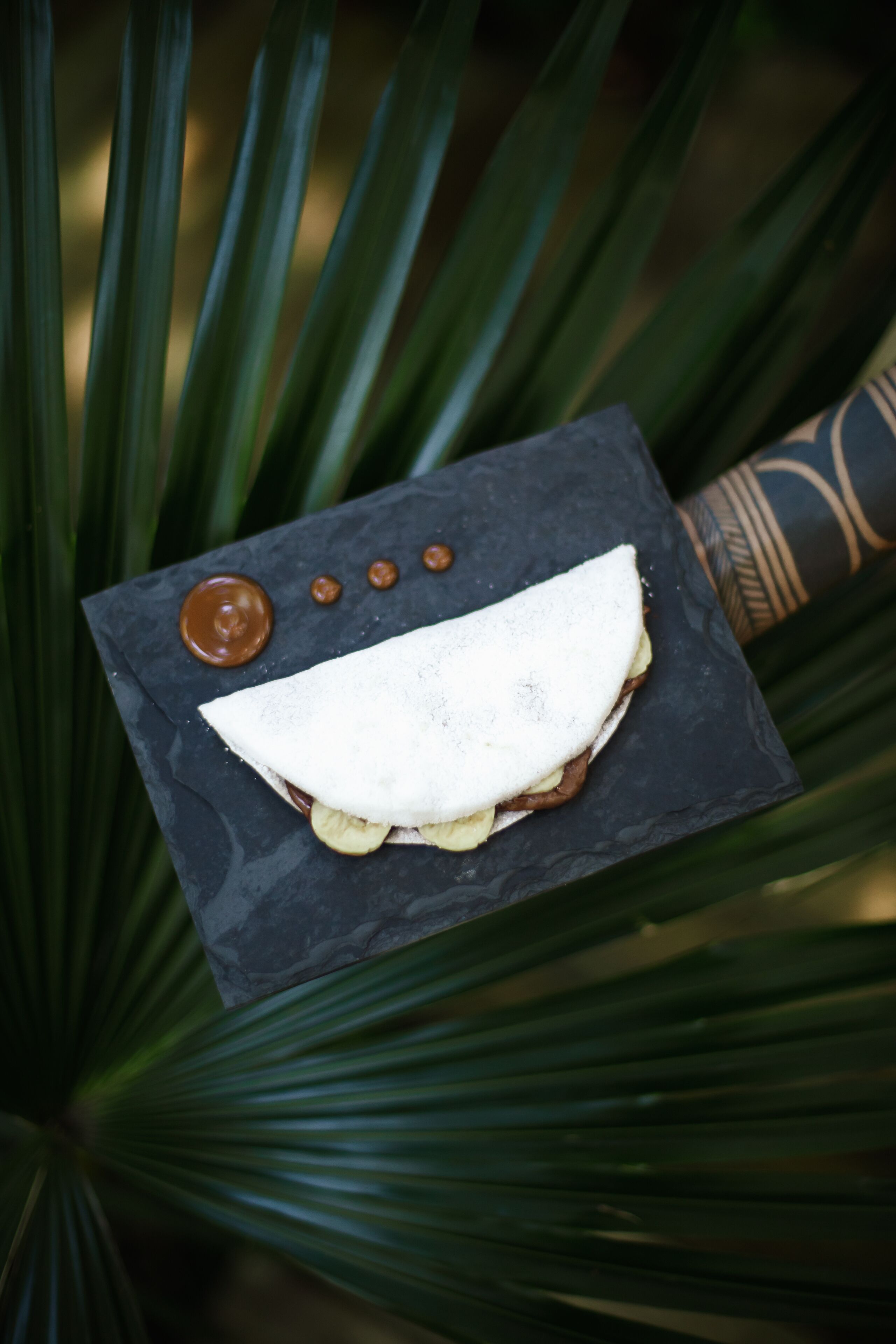A dessert on a slate plate with a dark background.