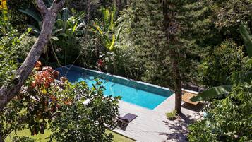 Una piscina al aire libre, sillones reclinables de piscina