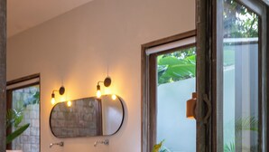 Un baño moderno con un espejo grande, dos lavamanos y una ducha.