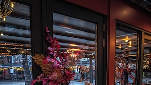 Ein Restaurantinneres mit einem Tisch, Stühlen und einer Blumenvase.