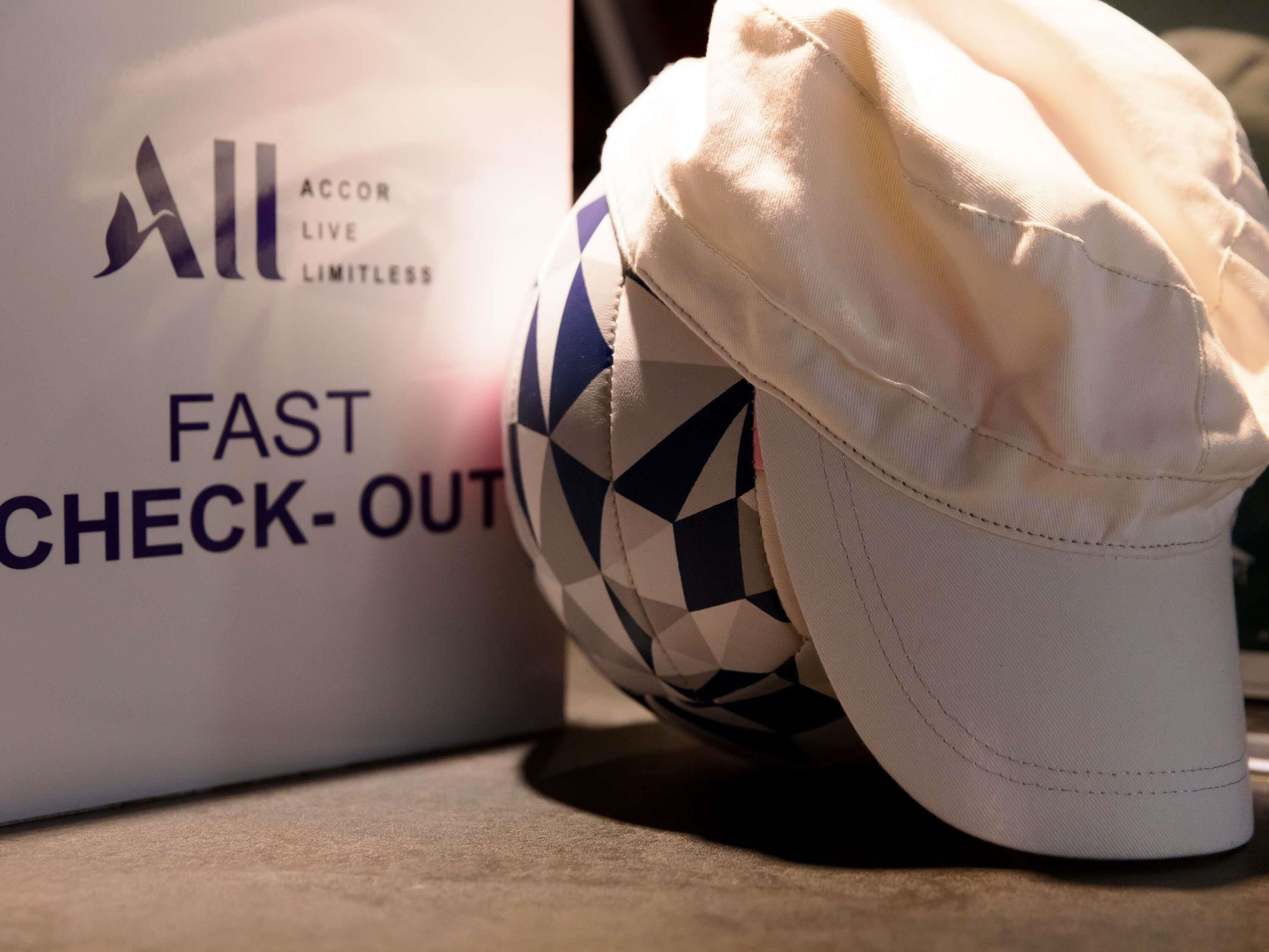 A white cap with a geometric pattern and a white box with text and a logo.