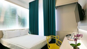 A hotel room with a bed, a desk with a chair, a TV, and a potted plant. - ibis Styles Dunarea Galati (Galati)