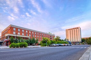 Situated on a street corner, this hotel features a classic brick facade and a prominent sign.