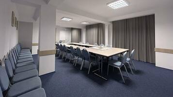 A conference room with a long table, chairs, and a carpeted floor.