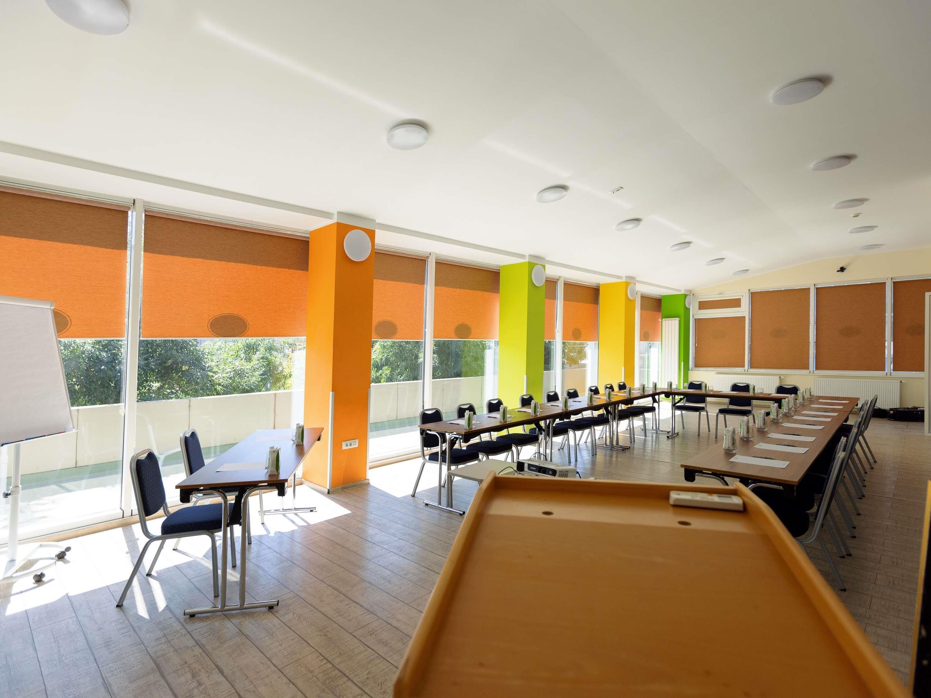 A conference room with a long table, chairs, and a whiteboard.