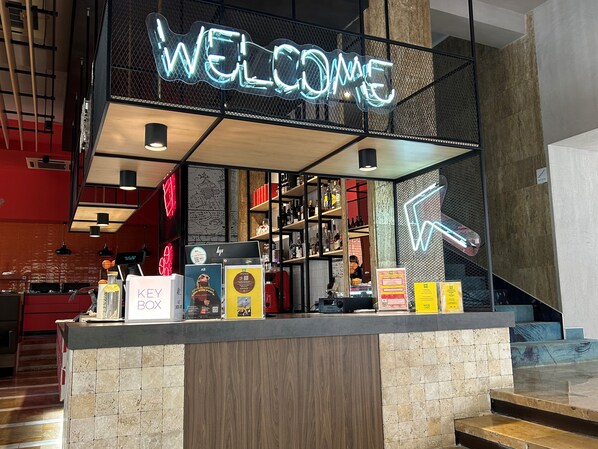 Een receptiegedeelte met een neon 'WELCOME' bord, een KEYSER BOX presentatie en diverse producten op planken.