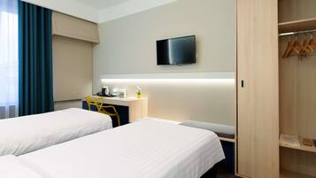 A hotel room with two beds, a desk, a television, and a wardrobe.