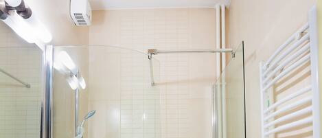 A modern bathroom with a glass shower enclosure, a white sink, and a glass-enclosed bathtub.