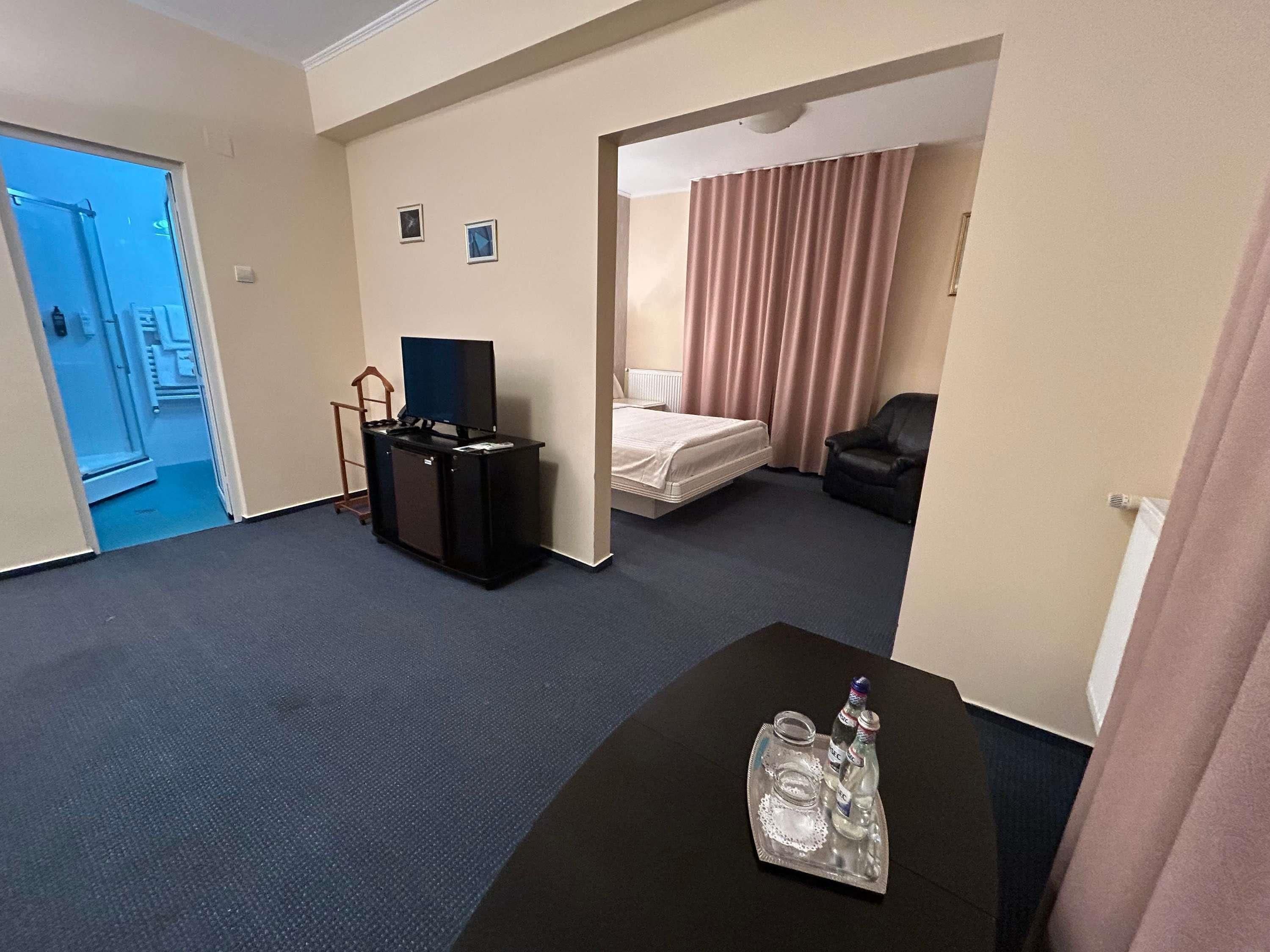 Une chambre d’hôtel avec un lit, un bureau avec une télévision, une chaise et une petite table avec un plateau.
