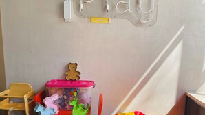 A children's play area with a 'Play' sign, a red table, yellow stools, a pink and green toy storage unit, and a red bean bag chair. - ibis Styles Dunarea Galati (Galati)