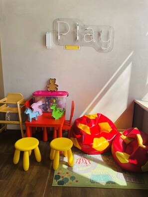 Children can play and relax in this cozy space with a play table, bean bag chair, and colorful play mat.