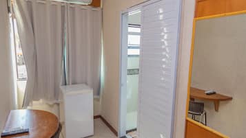 Minibar, escritorio, cortinas blackout y tabla de planchar con plancha