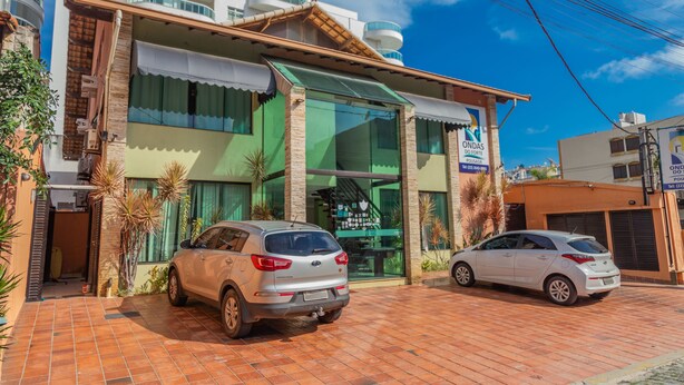 A building with a green awning and a sign that reads "ONDAS DO FORTE." - Pousada Ondas do Forte (Cabo Frio)