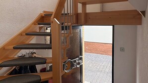 A wooden staircase with a glass door leading to an outdoor area. - Apartment Hope Inn (Gross-Zimmern)