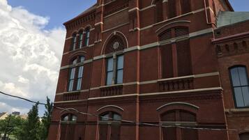 A red brick building with arched windows and a clock tower.