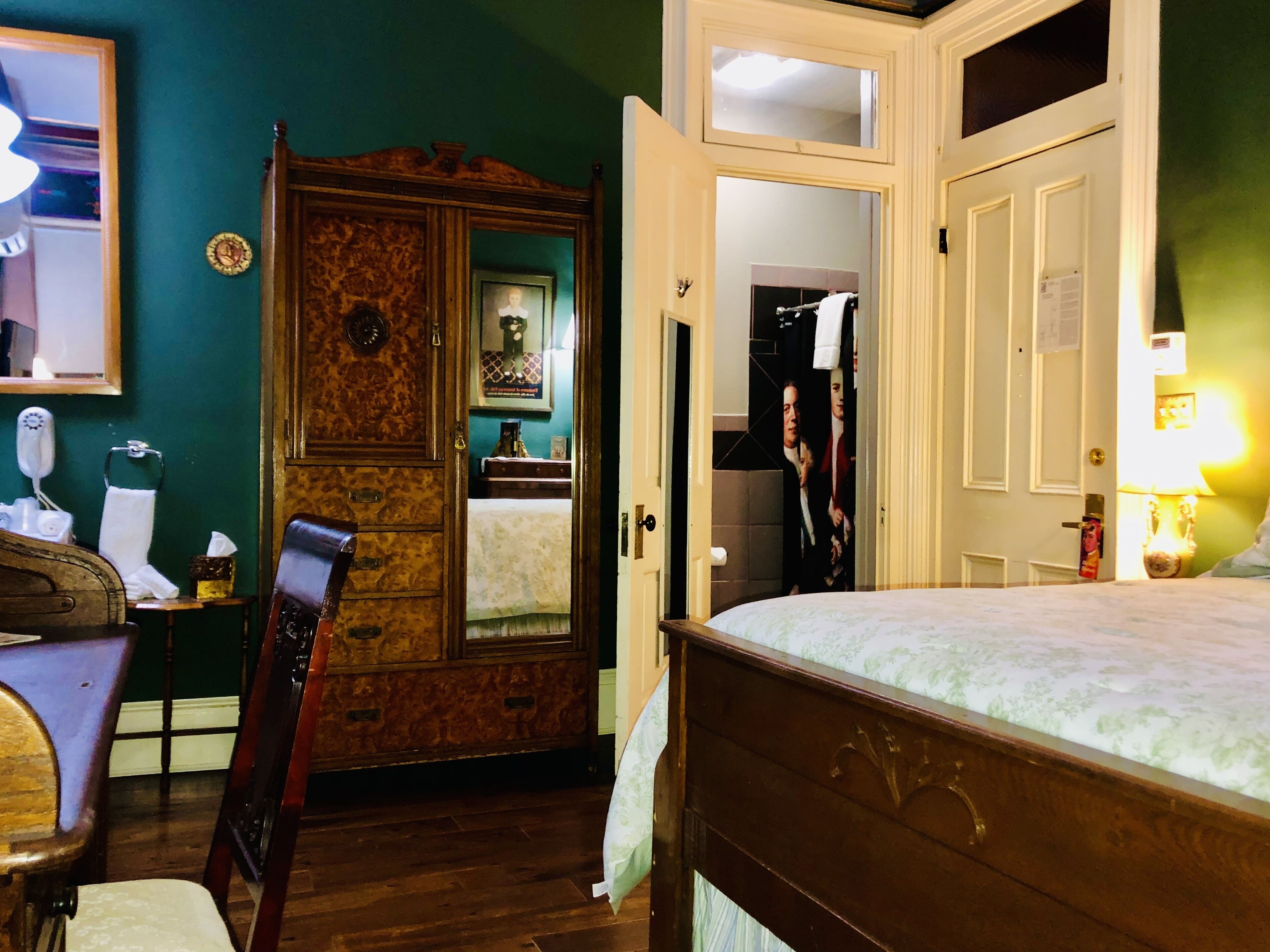 A bedroom with a wooden bed, a dresser, and a mirror.