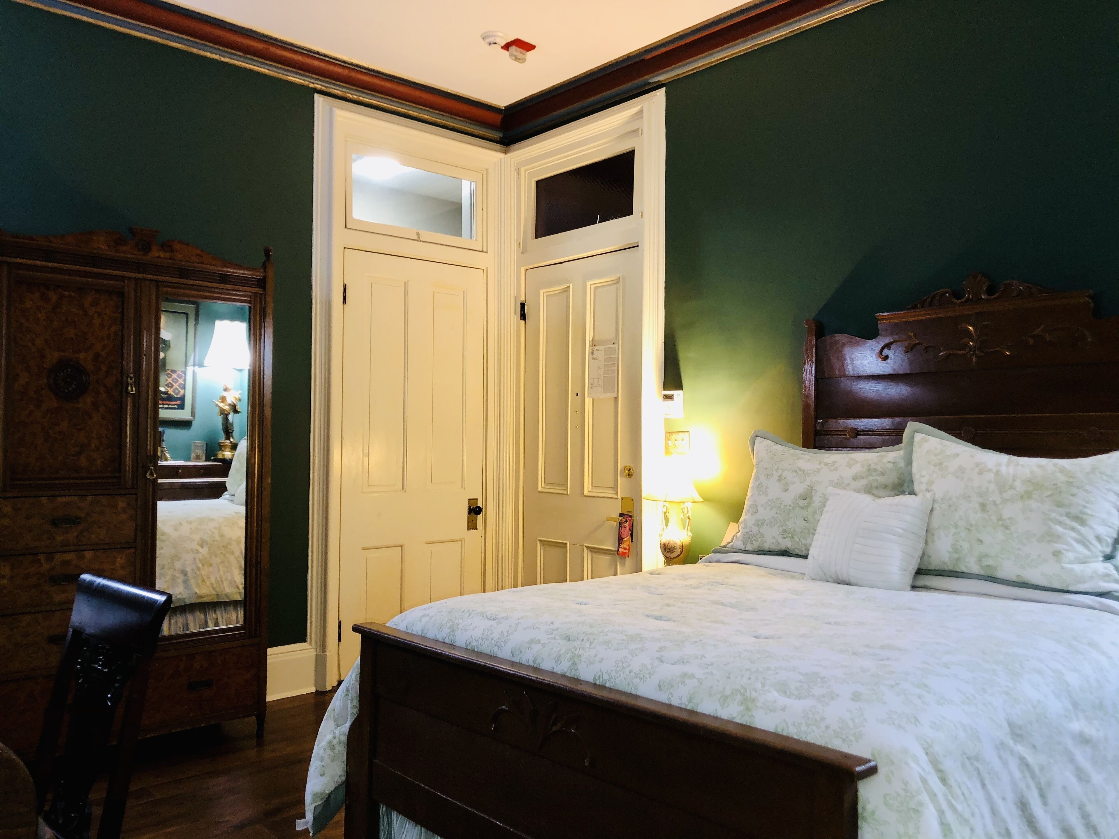 A bedroom with a bed, dresser, and a mirror.