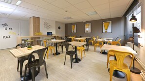 A classroom with multiple tables and chairs, a whiteboard with motivational text, and a window with blinds. - Apparteo Dijon (Dijon)