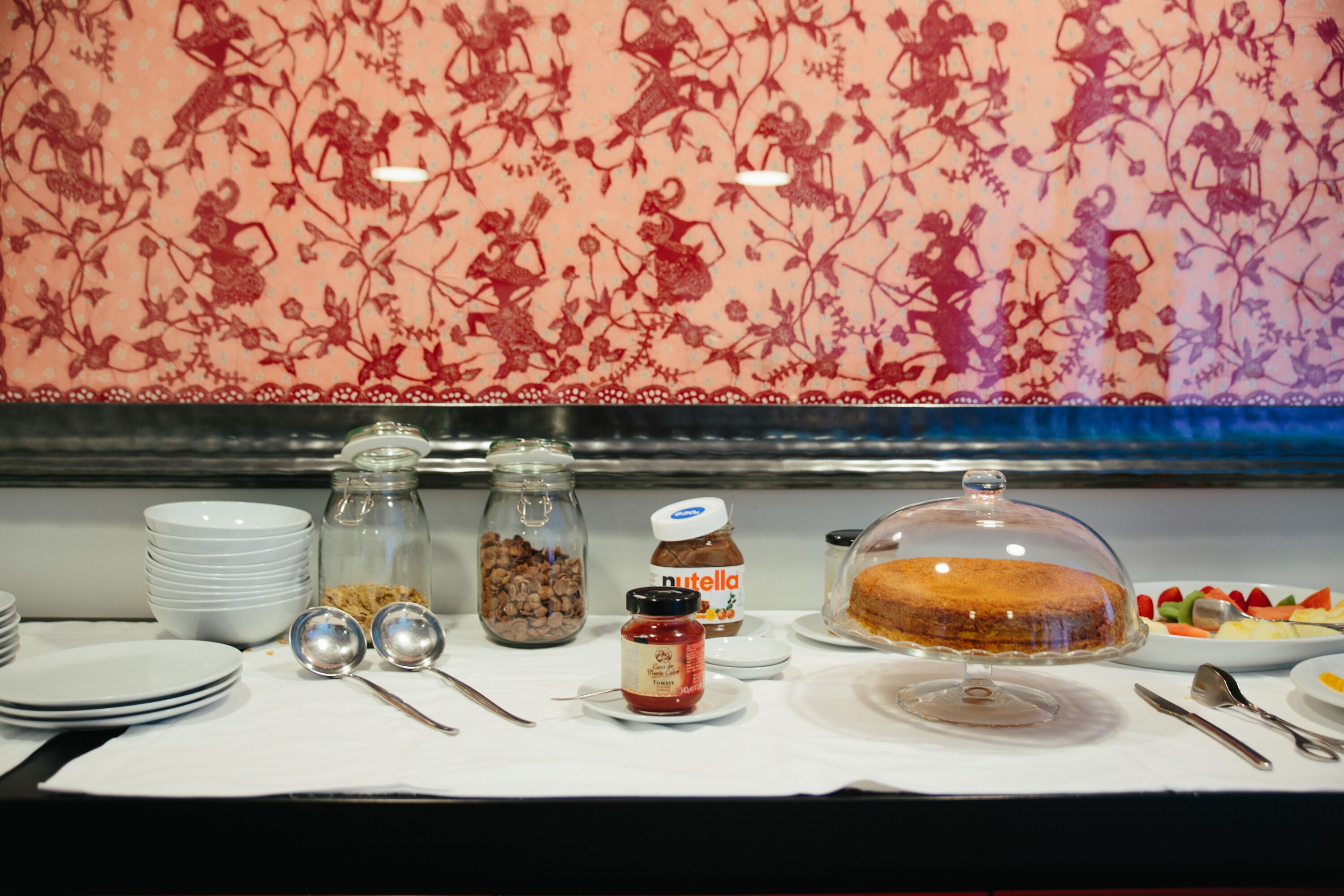 A breakfast buffet with various food items, including a cake, fruit, and condiments.