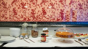 A breakfast buffet with various food items, including a cake, fruit, and condiments.