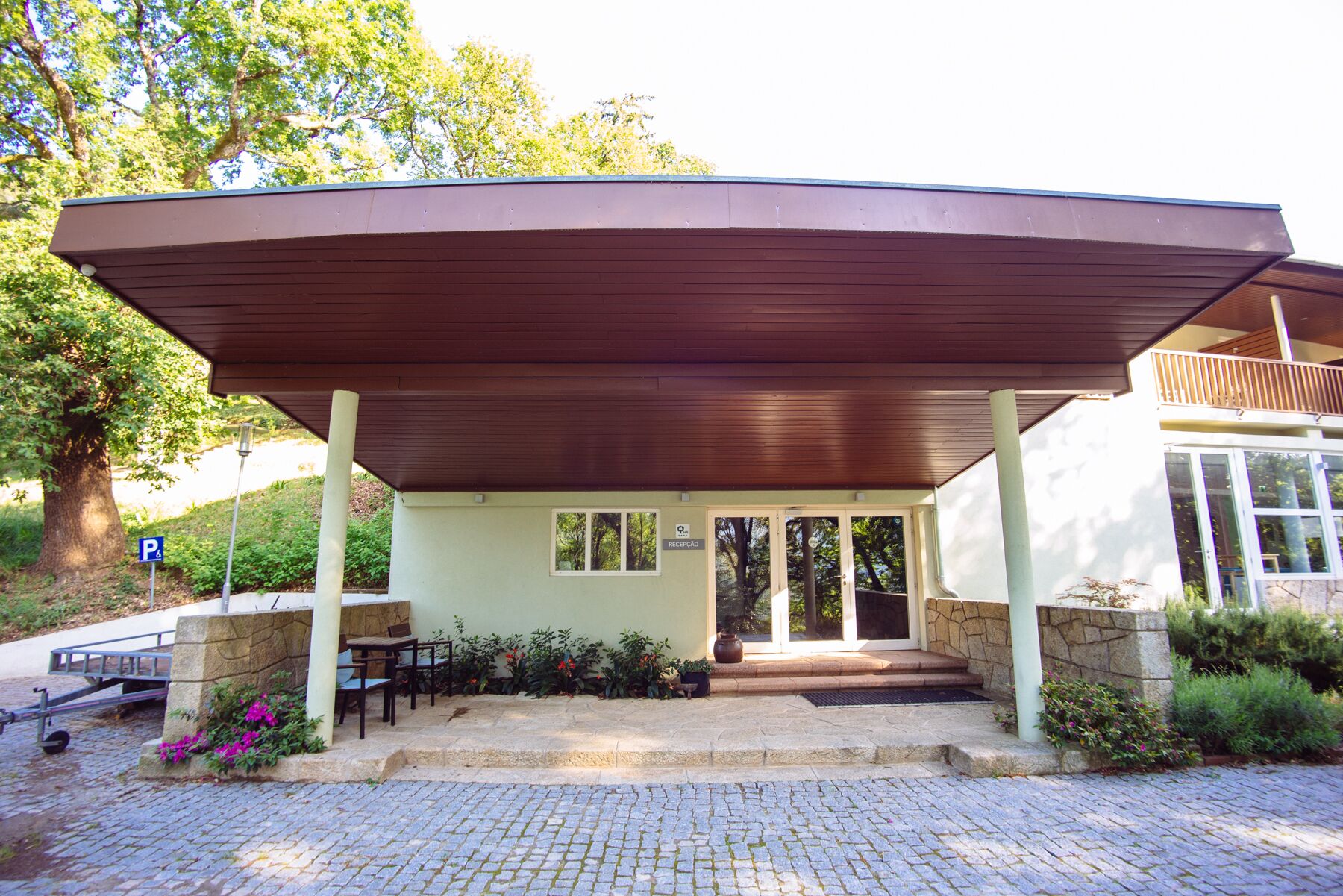 A covered outdoor area with a reception desk, stone steps, and a wheelchair-accessible ramp.