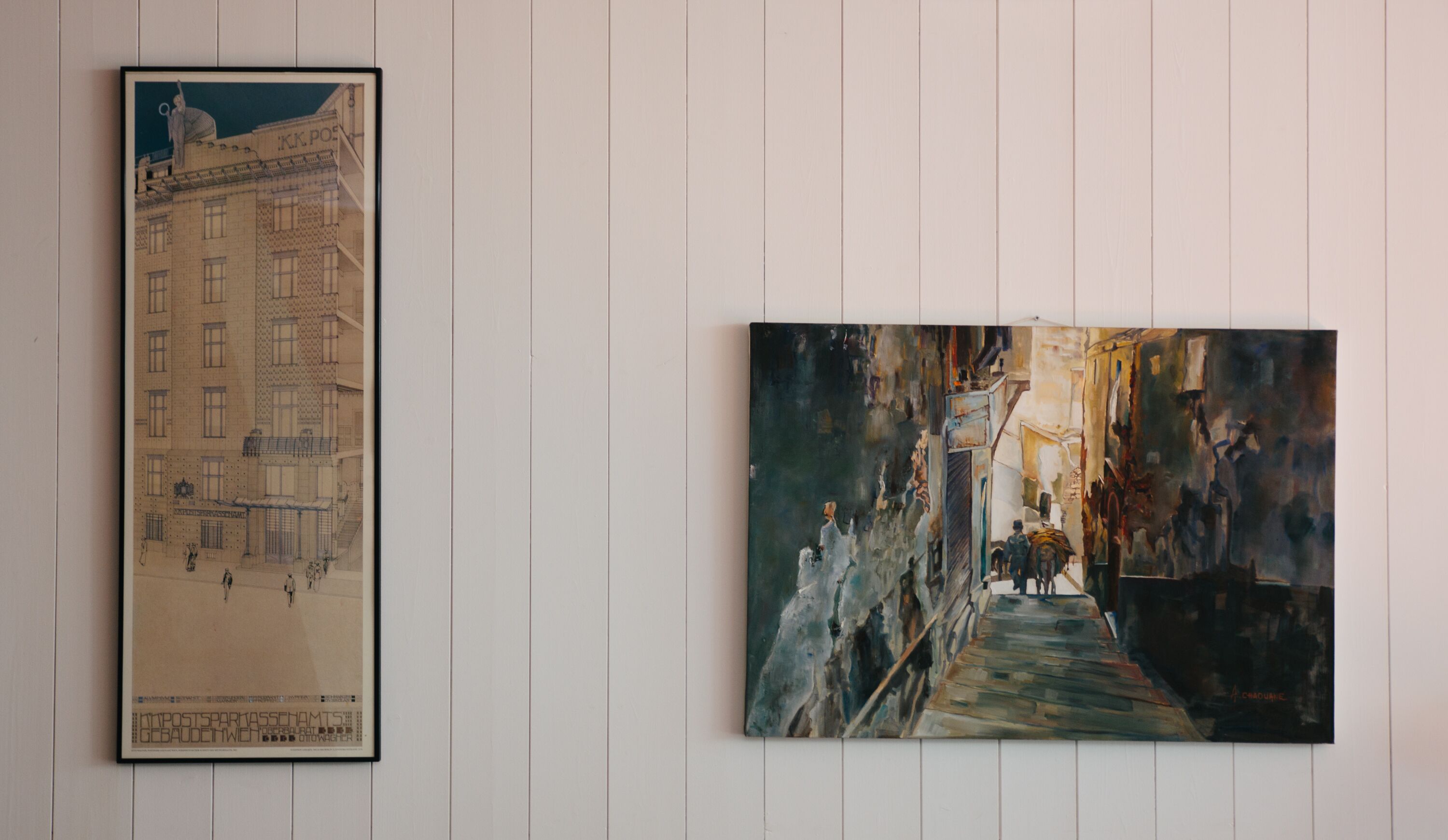 Two framed artworks on a white wall.
