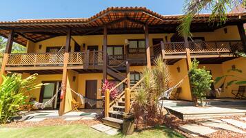 A two-story building with a balcony, a staircase, and a hammock.