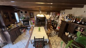 A traditional kitchen with a dining table, chairs, and various kitchen appliances.