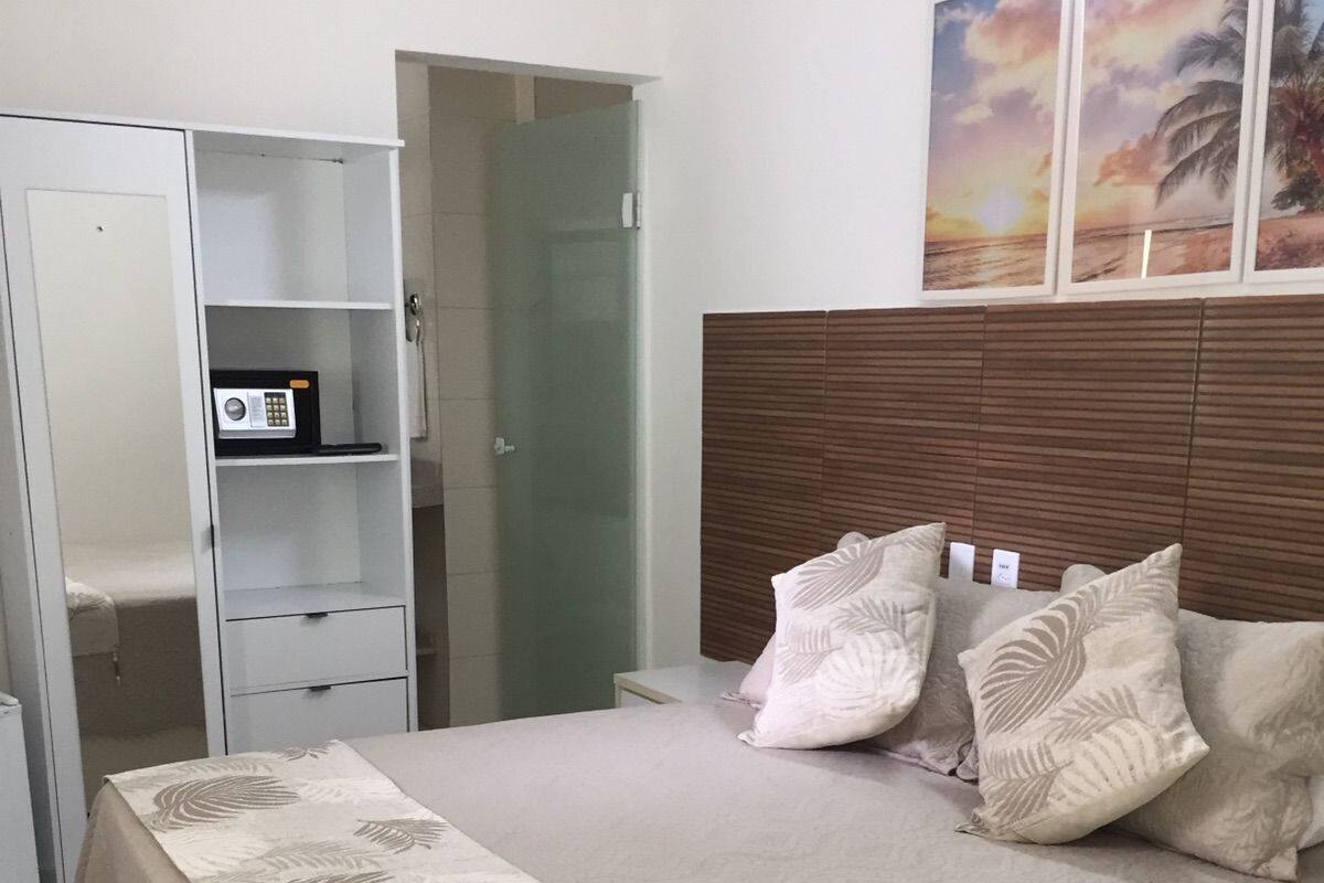 Une chambre à coucher avec un lit, une armoire, une table de chevet et un tableau au mur.