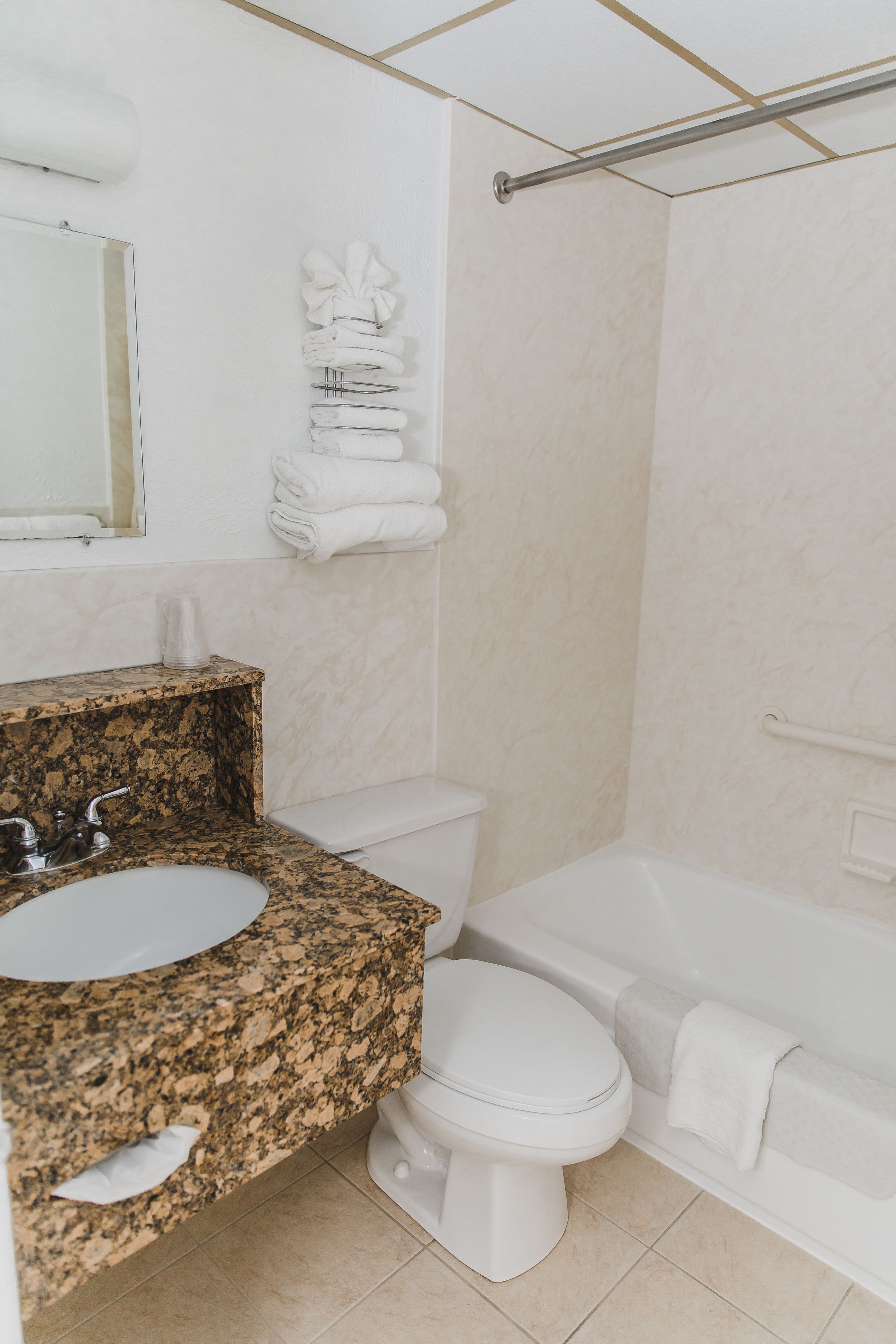 Ein Badezimmer mit Granitwaschtisch, Toilette und Badewanne.