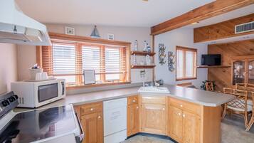Una cucina moderna con mobili in legno, forno a microonde integrato e lavastoviglie.