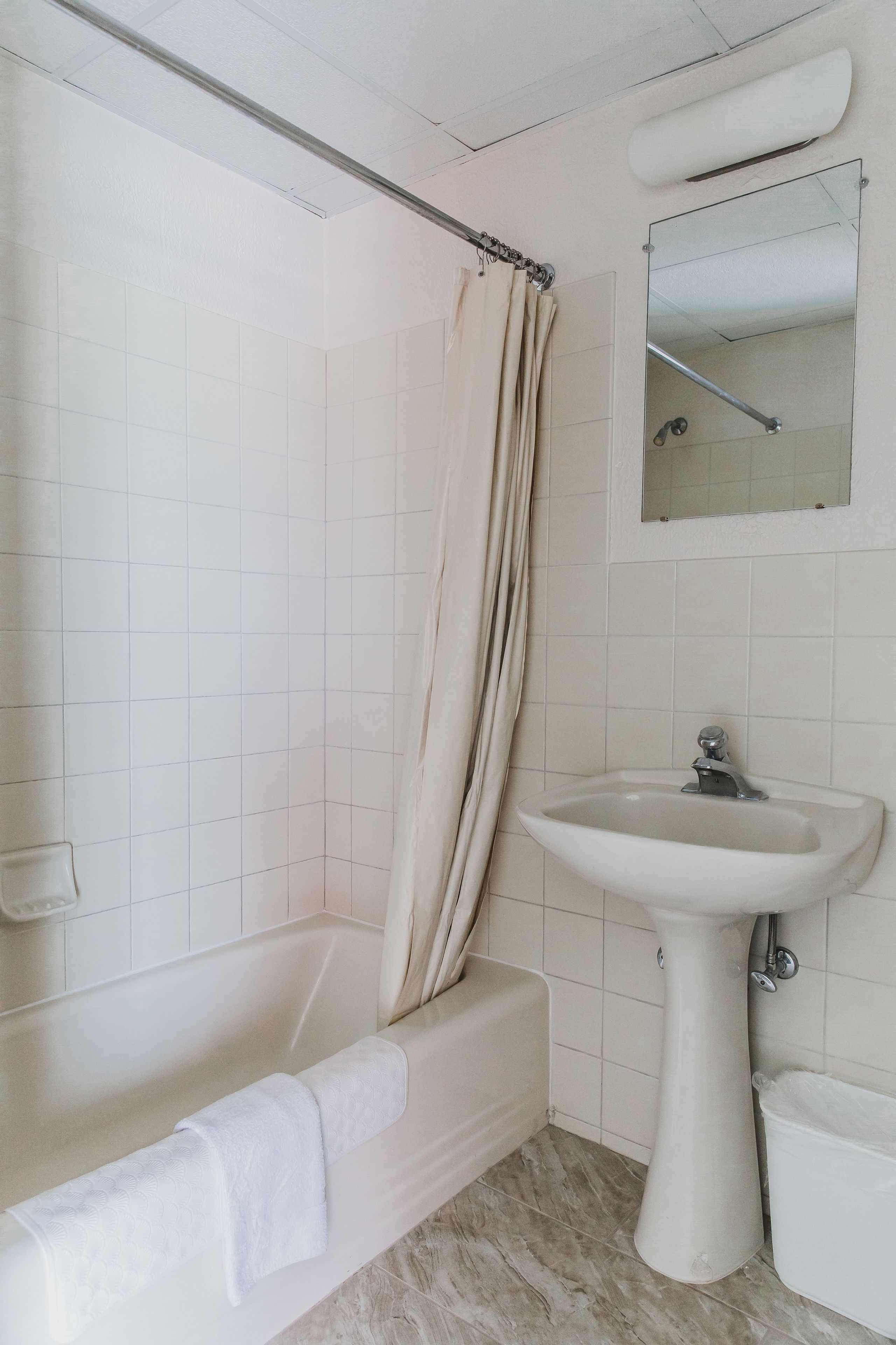 Ein Badezimmer mit Badewanne, Waschbecken und Duschvorhang.