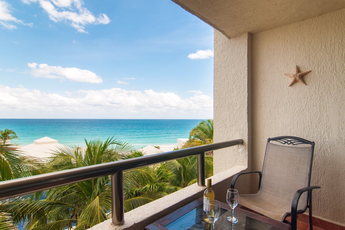 Ein Balkon mit Blick auf das Meer, eine Seestern-Dekoration und ein Tisch mit Flasche und Glas.