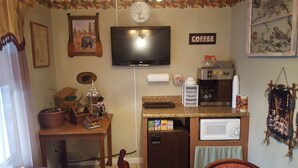 A kitchen with a TV mounted above the counter, a coffee machine, and various kitchen appliances. - Chatuge Mountain Inn (Hayesville)