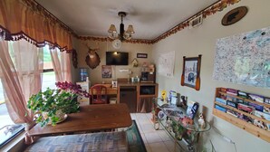 A cozy room with a wooden table, a water dispenser, a coffee machine, a map on the wall, and a mounted deer head. - Chatuge Mountain Inn (Hayesville)