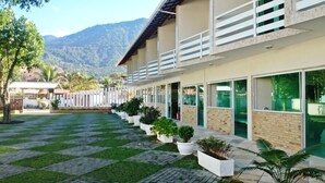 Un hotel con un espacio exterior cubierto, plantas en macetas y vistas a montañas.